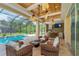 Relaxing poolside patio with wicker furniture and an outdoor kitchen at 8074 Wiltshire Dr, Port Charlotte, FL 33981