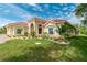 Tan house with tile roof, landscaping, & palm trees at 8074 Wiltshire Dr, Port Charlotte, FL 33981