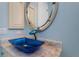 Modern bathroom sink with blue glass bowl and marble countertop at 8074 Wiltshire Dr, Port Charlotte, FL 33981
