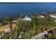 Aerial shot showcasing a secluded waterfront property surrounded by lush trees and tranquil blue waters at 6895 Manasota Key Rd, Englewood, FL 34223