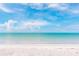 Stunning beach view featuring pristine sands and crystal-clear waters under a bright, cloud-filled sky at 6895 Manasota Key Rd, Englewood, FL 34223