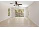 Bright bedroom featuring tiled floors, neutral walls, ceiling fan and large sliding glass doors to outdoor deck at 6895 Manasota Key Rd, Englewood, FL 34223