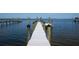 Wooden dock with pilings extending into the calm bay waters at 6895 Manasota Key Rd, Englewood, FL 34223