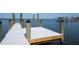 Close-up view of wooden dock pilings extending into the bay with boats in background at 6895 Manasota Key Rd, Englewood, FL 34223