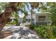 Elegant two-story home with lush landscaping, inviting porch, and beautiful mature trees at 6895 Manasota Key Rd, Englewood, FL 34223