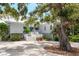 Charming two-story home with white exterior, grand oak tree, and inviting entrance at 6895 Manasota Key Rd, Englewood, FL 34223