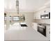 Bright modern kitchen features white cabinets, stainless steel appliances, a large island with sink and a view of the water at 6895 Manasota Key Rd, Englewood, FL 34223