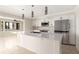 Bright, modern kitchen with stainless steel appliances, a center island, pendant lighting, and tile flooring at 6895 Manasota Key Rd, Englewood, FL 34223