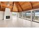 Open living room featuring a stone fireplace, vaulted ceilings, tile floors, and a stunning water view at 6895 Manasota Key Rd, Englewood, FL 34223