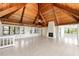 Bright living room featuring a vaulted wood ceiling, tile floors, a cozy fireplace, and walls of windows at 6895 Manasota Key Rd, Englewood, FL 34223