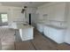 Bright kitchen showcasing white cabinets, quartz countertops, large island, and modern design, still under construction at 5462 Gagnon Ter, North Port, FL 34291