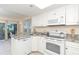 Kitchen with granite countertops, white cabinets, and ocean view at 7446 Palm Island Dr # 3514, Placida, FL 33946