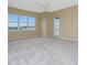 Primary bedroom with large windows, balcony access, and ceiling fan at 10540 Amberjack Way # 302, Englewood, FL 34224