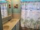 Bathroom with double vanity, beach-themed shower curtain at 745 Coral Way, Englewood, FL 34223