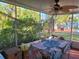 Screened patio with table, chairs, and view of the backyard at 745 Coral Way, Englewood, FL 34223
