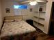 Bedroom with a full-size bed, built-in shelving, and window with shutters at 745 Coral Way, Englewood, FL 34223