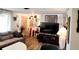 Living room with gray couch, large TV, and wood-look floors at 745 Coral Way, Englewood, FL 34223