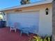 Attached garage with seating area and outdoor lighting at 745 Coral Way, Englewood, FL 34223