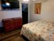 Bedroom with wood dresser, large bed, and TV at 745 Coral Way, Englewood, FL 34223