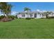 White house with metal roof, landscaping, and palm trees at 495 Coral Creek Dr, Placida, FL 33946