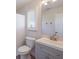 Simple bathroom with vanity, toilet, and window with shutters at 495 Coral Creek Dr, Placida, FL 33946