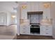 Modern kitchen features white cabinets, stainless steel appliances, and updated backsplash at 495 Coral Creek Dr, Placida, FL 33946
