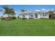 White house with metal roof, landscaping, and palm trees at 495 Coral Creek Dr, Placida, FL 33946