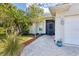 Charming home featuring a paved walkway, lush landscaping, and a welcoming screened entrance at 7192 N Paragon Rd, North Port, FL 34291