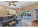 Living room with hardwood floors, gray sectional sofa, and access to backyard patio at 7192 N Paragon Rd, North Port, FL 34291