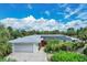 Single-story home with a gray metal roof, solar panels, and red door at 120 Barracuda Dr, Placida, FL 33946