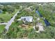 Aerial view of single-story home with lush landscaping, canal, and solar panels at 120 Barracuda Dr, Placida, FL 33946