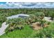 An aerial view showcasing a single-story house surrounded by tropical landscaping and solar panels at 120 Barracuda Dr, Placida, FL 33946