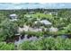Aerial view showcasing a single-story home, private dock, and tropical foliage at 120 Barracuda Dr, Placida, FL 33946