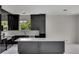 Modern kitchen with large island, black cabinets, and white countertops at 118 Green Pine Park, Rotonda West, FL 33947