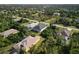 Aerial perspective of a house within a residential area, showing surrounding homes at 118 Green Pine Park, Rotonda West, FL 33947
