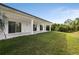 House exterior showcasing a large backyard and covered patio at 118 Green Pine Park, Rotonda West, FL 33947