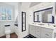 Stylish bathroom with white cabinets and a navy mirror at 10470 Sunny Dreams Ter, Placida, FL 33946