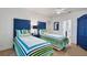 Twin bedroom with blue and green striped bedding at 10470 Sunny Dreams Ter, Placida, FL 33946