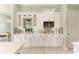 White kitchen cabinets and quartz countertops with decorative backsplash at 777 Boundary Blvd, Rotonda West, FL 33947