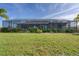 Large backyard with lush grass and screened patio at 9303 Migue Cir, Port Charlotte, FL 33981