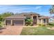One-story house with two-car garage, lush landscaping and brick paver driveway at 9303 Migue Cir, Port Charlotte, FL 33981