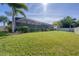Spacious backyard with lush lawn and screened enclosure at 9303 Migue Cir, Port Charlotte, FL 33981