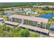 Aerial shot of condo community featuring multiple buildings, parking, and tennis courts at 175 Kings Hwy # 1014, Punta Gorda, FL 33983