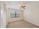 Carpeted bedroom featuring a ceiling fan, window with blinds, and closet at 175 Kings Hwy # 1014, Punta Gorda, FL 33983