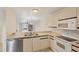 Bright kitchen with tile floors, white appliances, and bar counter overlooking the living room at 175 Kings Hwy # 1014, Punta Gorda, FL 33983