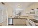 Bright kitchen with tile floors, white appliances, and bar counter overlooking the living room at 175 Kings Hwy # 1014, Punta Gorda, FL 33983