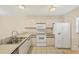 Bright kitchen with tile floor and white appliances, including fridge, microwave, and oven range at 175 Kings Hwy # 1014, Punta Gorda, FL 33983