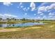 Scenic lake view with lush green surroundings and community buildings at 175 Kings Hwy # 1014, Punta Gorda, FL 33983