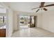 Living room space showcasing tile flooring, ceiling fan, and view through glass sliding doors at 175 Kings Hwy # 1014, Punta Gorda, FL 33983