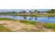 Scenic water view featuring a tranquil pond reflecting the sky, lush greenery, and community fencing at 175 Kings Hwy # 1014, Punta Gorda, FL 33983